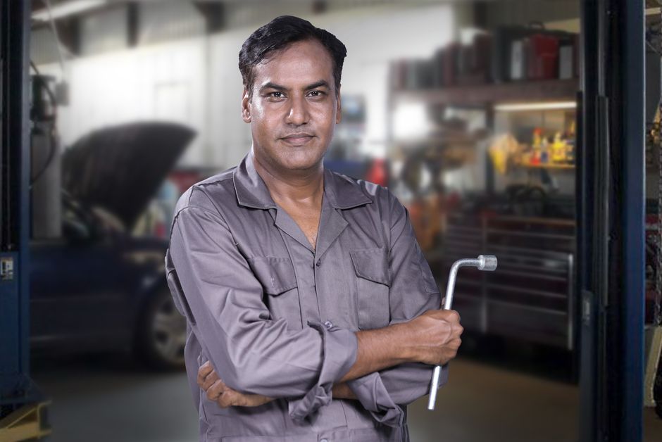 Friendly automotive technician ready to assist with tire rotation